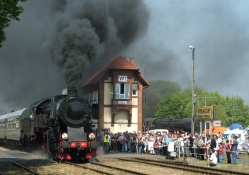 steam train coming into a polish station